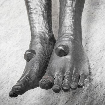 Nailed feet , detail of statue of Jesus Christ crucified.