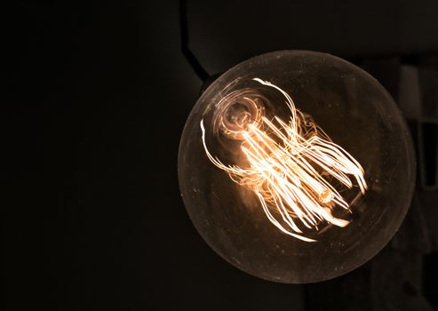 Close up glowing light bulb. Vintage lamp background. Shallow DOF.