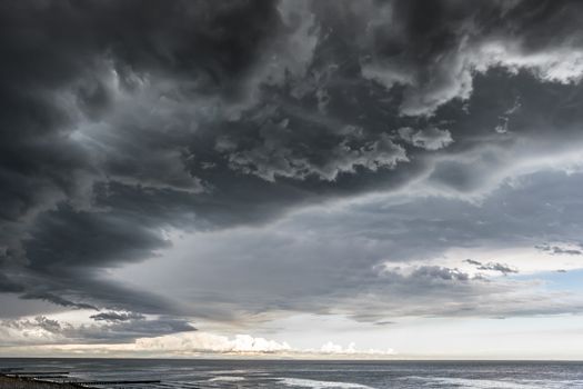 Landscape photo of a beach and dramatic thunderstorm clouds over the sea or the ocean