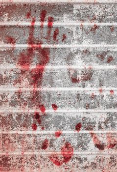 Bloody handprints and blotches of blood on grunge wall. Background for spooky content, halloween and more.