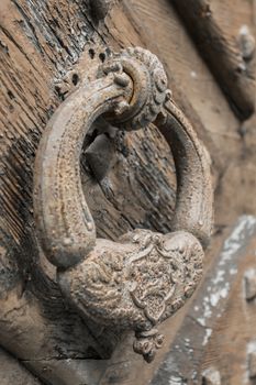 A large decorative vintage door handle on a wooden door