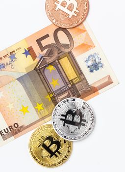 Financial concept with image of bitcoins on fifty euro banknote. Traditional money versus cryptocurrency concept.