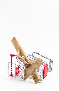 Shopping cart overturned with crucifix on the ground. Conceptual representation of commodification of religion, loss of faith, blasphemy.