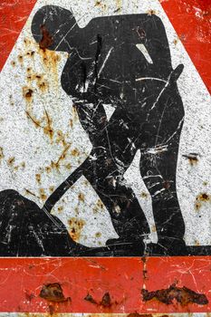 Old roadworks sign, under construction. Grungy warning red road sign, triangle shape with red border, working man isolated on a white background