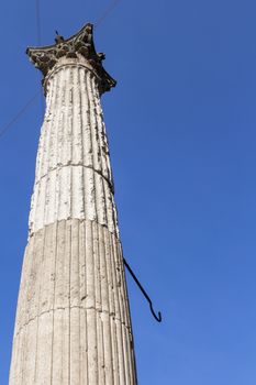 Ancient column dating back to Roman times, isolated with blue sky in the background.