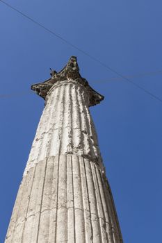 Ancient column dating back to Roman times, isolated with blue sky in the background.