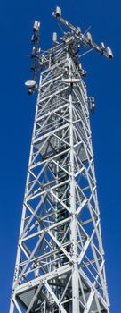 Bottom view of a communications tower with blue sky in the background.