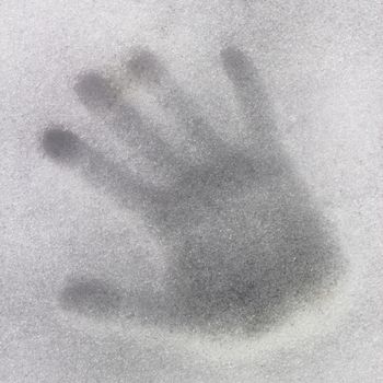 Horizontal view of a handprint on icy snow.
