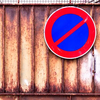 Signal of prohibition of parking on a rusty gate.