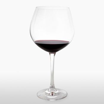 Horizontal shot of a glass of red wine on white background.