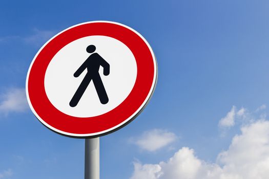 Walking forbidden sign on a blue sky with clouds