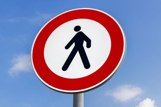 Walking forbidden sign on a blue sky with clouds