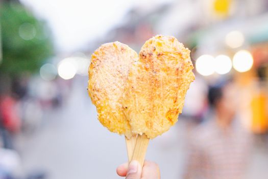 Closeup hand holding Grilled sticky rice with egg on walking street