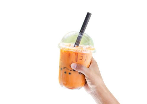 Closeup hand holding glass of ice thai tea on white background