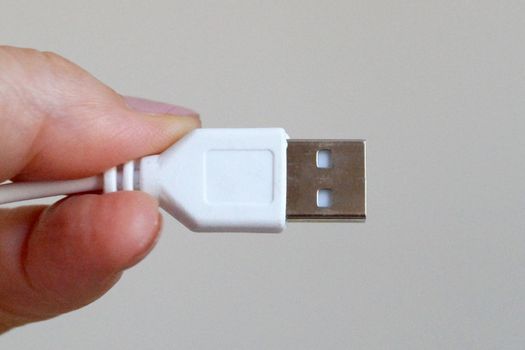 white usb cable in hand close-up