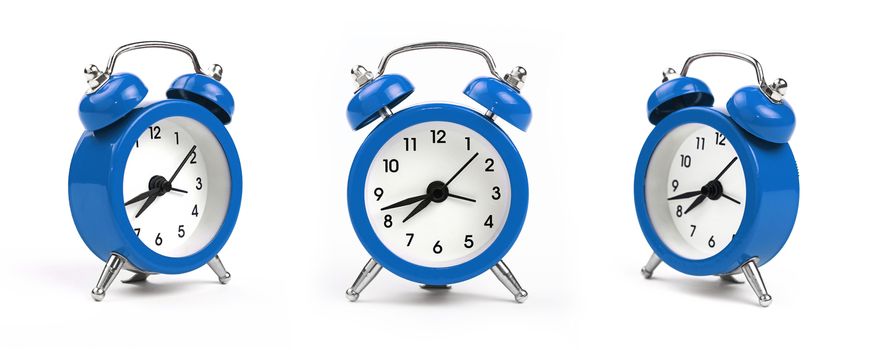 Three small blue metal alarm clock with red bells over white background, close up, low angle view in different perspectives