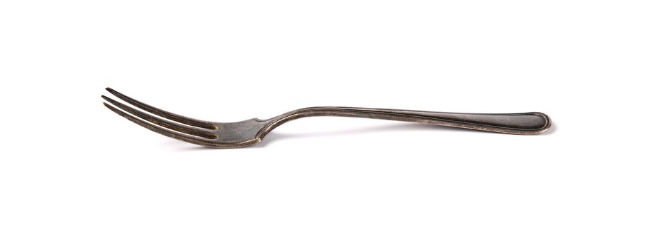 Close up one old vintage metal fork isolated on white background, low angle, side view