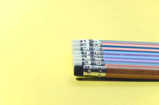 Closeup concept of a Group pencil with a single black eraser Placed on a yellow note book