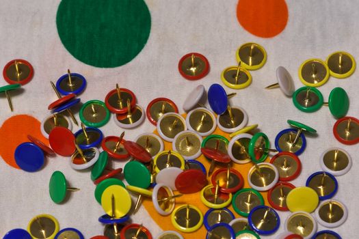 Scattered thumbtacks on a colored plane, horizontal image
