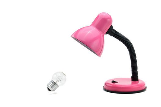 Red colored table lamp with a light bulb on a white isolated background