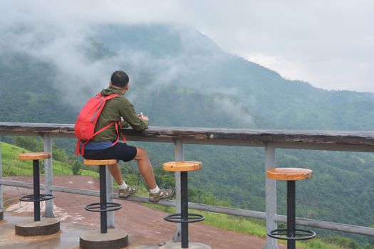 Man tourist backpacker relaxing outdoor sitting on a chair