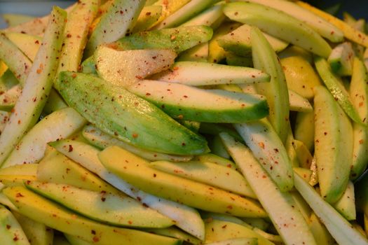 sprinkle with sugar, chili powder and salt on mango ** note select focus with shallow depth of field