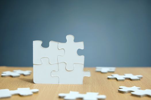 Conceptual photo of business strategy – four joined jigsaw puzzle with missing part