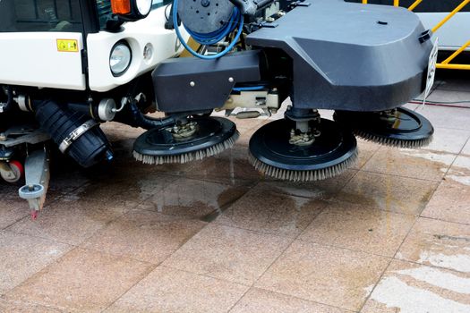 urban sweeper cleans road from dirt with a round brush

