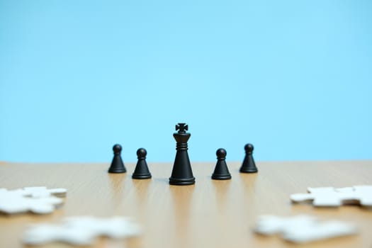 Business strategy conceptual photo - king and chess pawn in line, standing in front of jigsaw puzzle