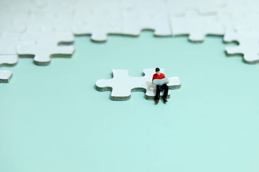 Business strategy conceptual photo - young man seat and reading above missing piece puzzle