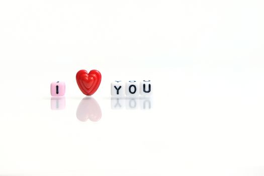 I heart you beads on shiny white background. Love and romance conceptual object photography