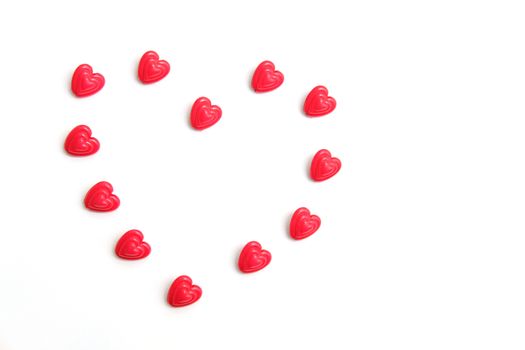 Red and pink heart beads shape, top view flat lay with white background. Love and romance conceptual object