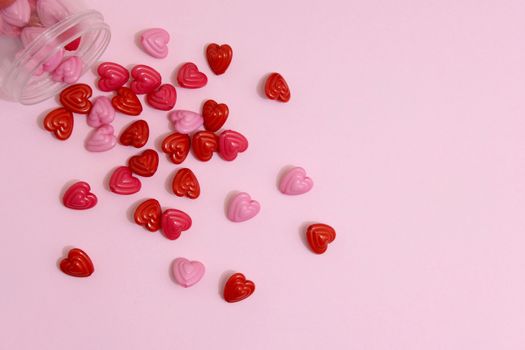 Red and pink heart beads shape, top view flat lay with pink background. Love and romance conceptual object