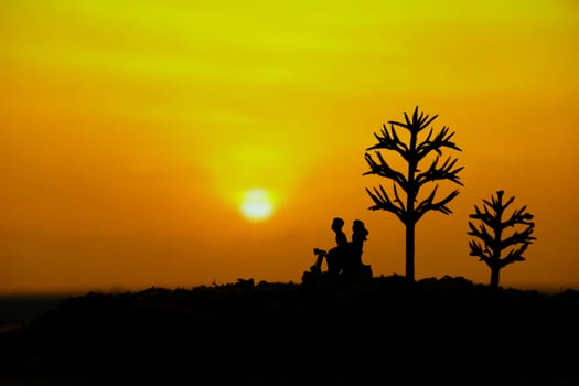 miniature people / toy photography - conceptual valentine holiday illustration. A couple silhouette riding a scooter at the sand beach