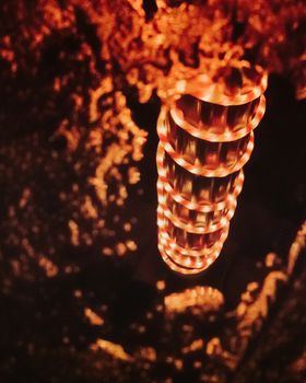 A Spiral of Bright Red and Light Christmas Lights Reflecting in a Pool of Water