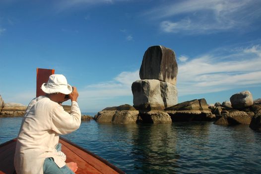 Tourists are taking pictures on the boat at Koh Hin Son.