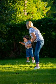 Mother turns little daughter in circle holding her hands