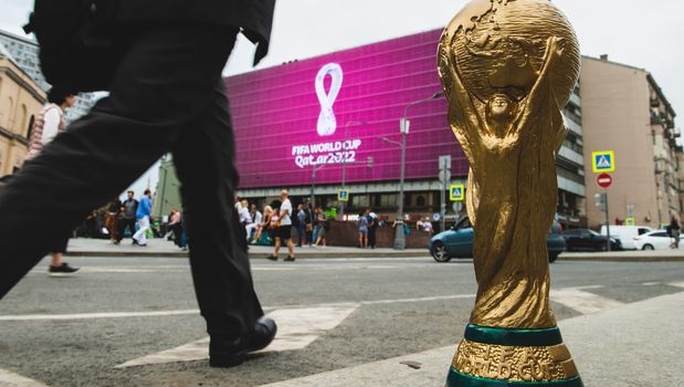 4 September 2019, Moscow, Russia. Copy of world cup trophy on background logo of the FIFA world Cup 2022, which will be held in Qatar, on a giant screen in the city center.