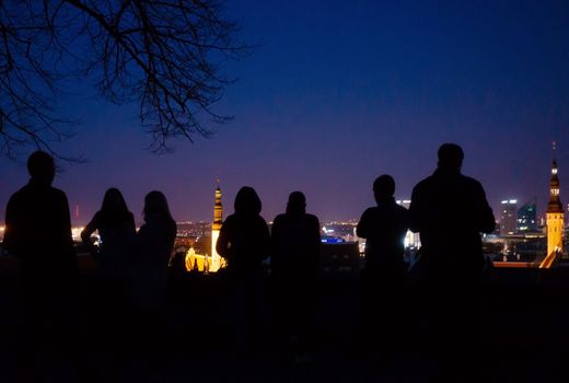 April 20, 2018, Tallinn, Estonia. Silhouettes of tourists on the observation deck in the old city in Tallinn at night.