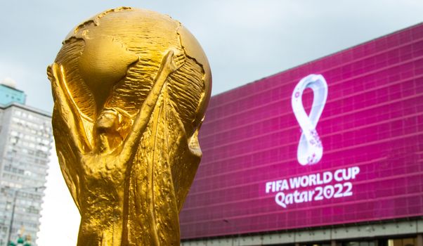 4 September 2019, Moscow, Russia. Copy of world cup trophy on background logo of the FIFA world Cup 2022, which will be held in Qatar, on a giant screen in the city center.