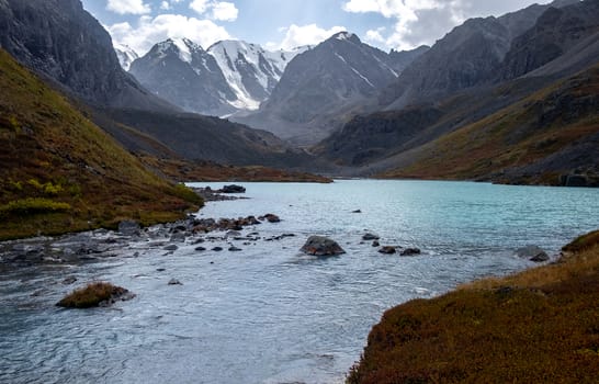 Mountain lake on the background of snow-capped peaks in the Altai Republic.