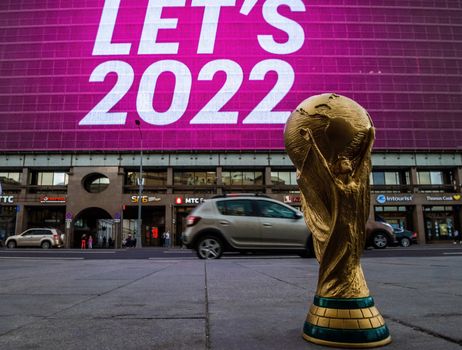 4 September 2019, Moscow, Russia. Copy of world cup trophy on background logo of the FIFA world Cup 2022, which will be held in Qatar, on a giant screen in the city center.