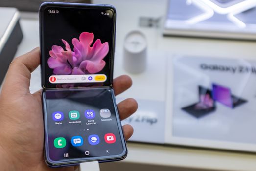 February 22, 2020, Moscow, Russia. New folding smartphone with a folding screen Samsung Galaxy Z Flip on the store counter.