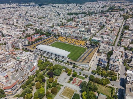 Aerial top day view of empty football court Kleanthis Vikelidis with green pitch & team name written on stands.
