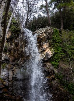 Waterfall on a mountain river in the hot summer in the mountains of Central Cyprus.