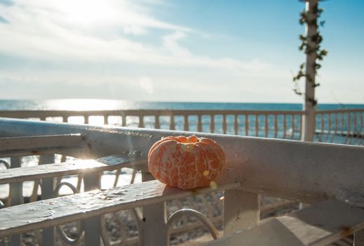 Peeled tangerine on the table of a summer cafe on the beach.