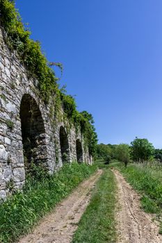 Footpath in countryside with ancient medieval wall