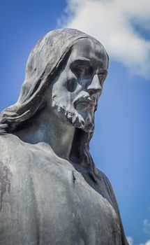 Christ the Redeemer statue. In the background, blue sky and clouds