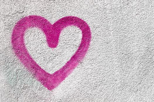 Pink heart shaped on wall background. Symbol of love on rustic wall. It can be used as a Valentine's theme, poster, wallpaper, design t-shirts and more.