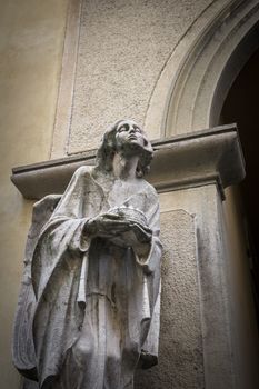 Marble statue of a woman holding a crown in his hands.